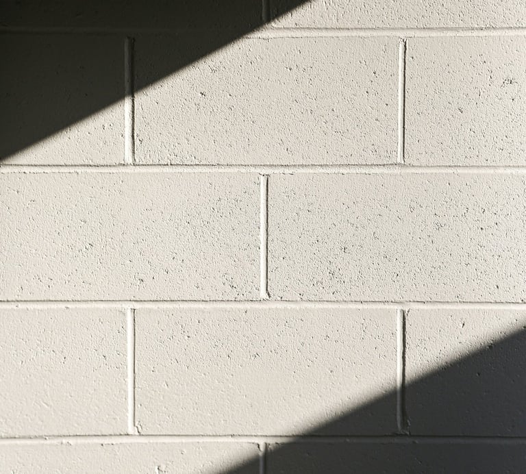 White concrete block wall with diagonal shadows.
