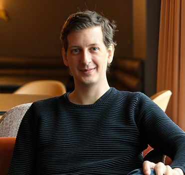 a man sitting on a couch with a remote control