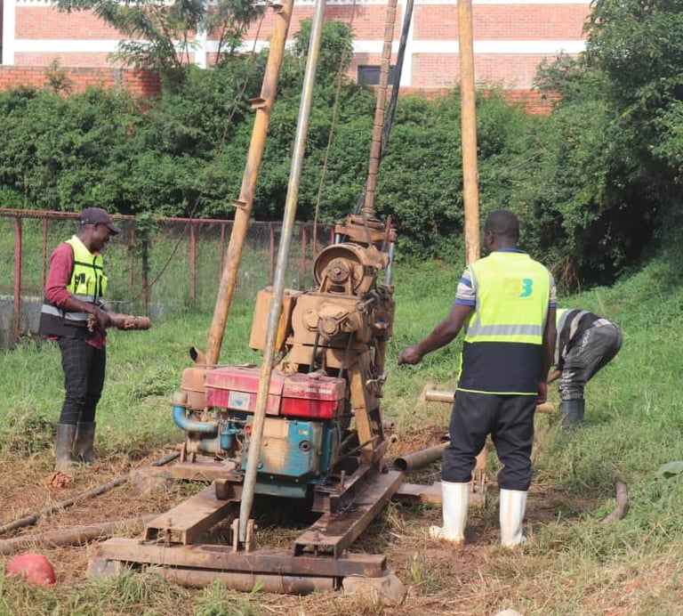 Drilling rig performing geotechnical soil investigation with engineers supervising.