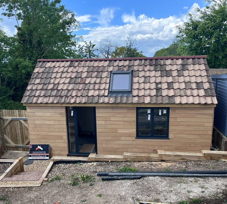 Front view of fully insulated Brighton garage conversion with timber exterior and rooflight window