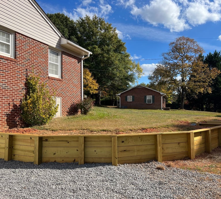 Pressure-treated timber retaining wall installation in Newton NC for yard leveling and slope correct