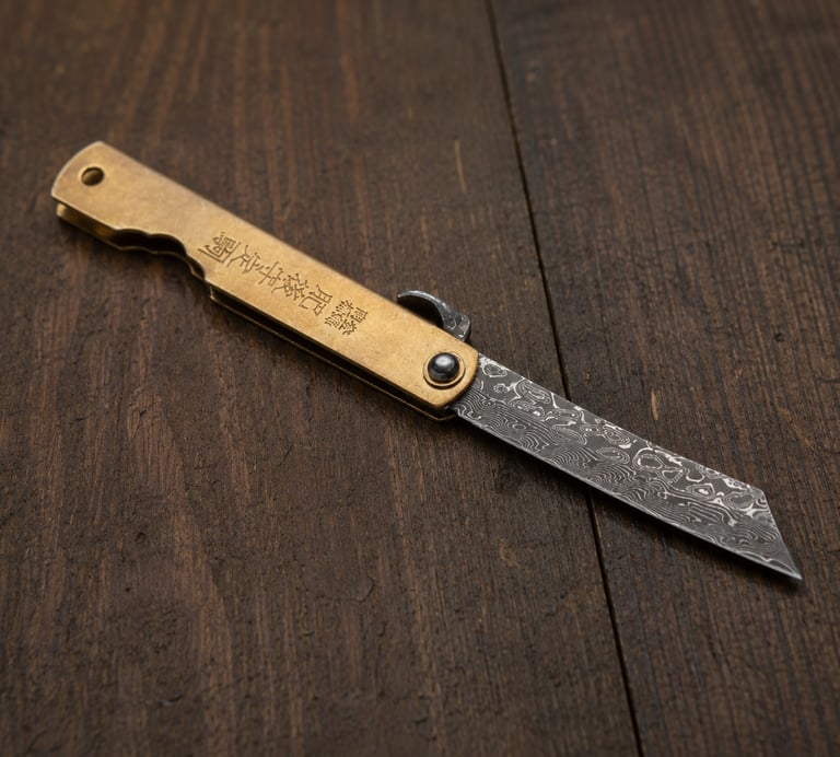 A Japanese Higonokami folding knife with a Damascus steel blade and brass handle on a dark wood surface.