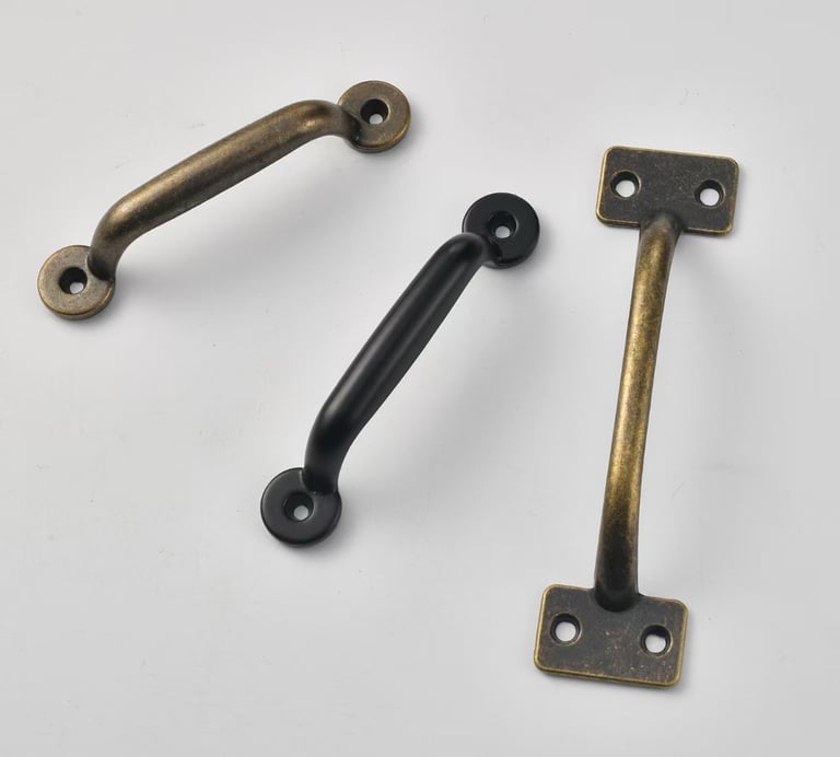 Vintage style cabinet pull handles in antique brass and matte black finishes for drawer hardware.
