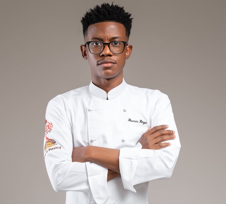 a male chef in a white uniform and glasses