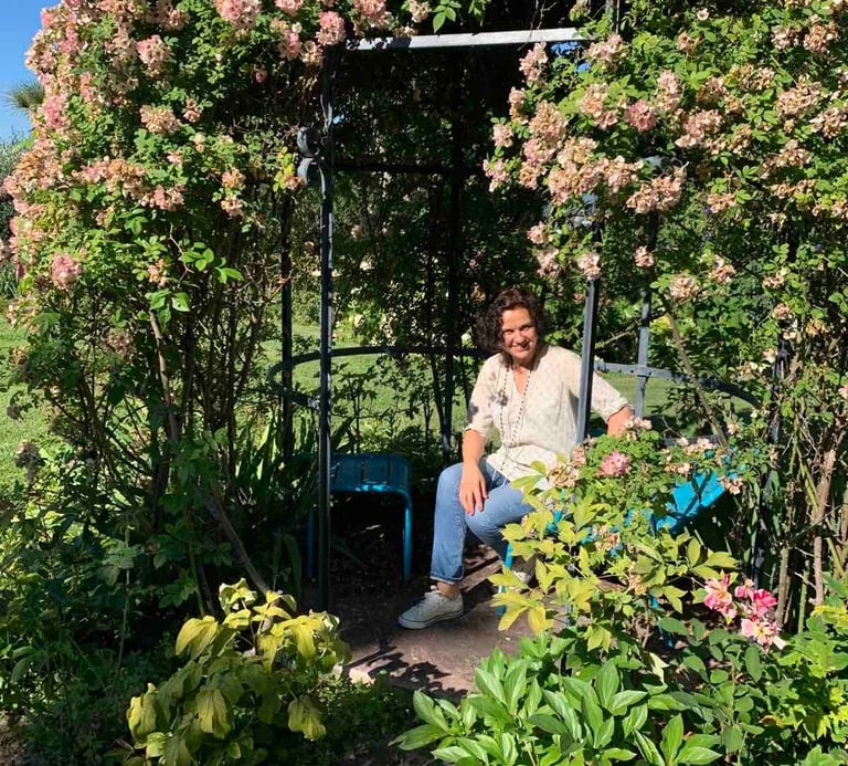 a woman sitting on a bench in a garden