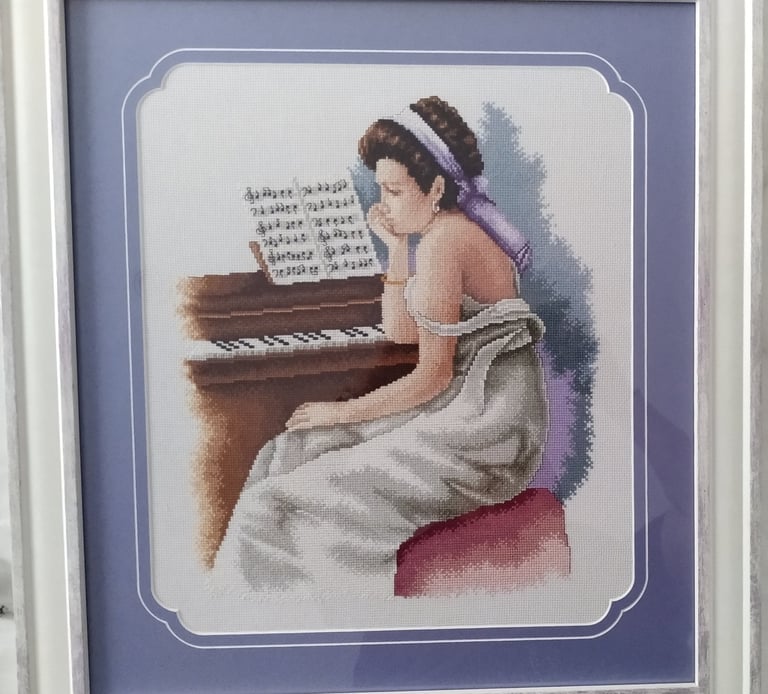a woman in a white dress sitting at a piano