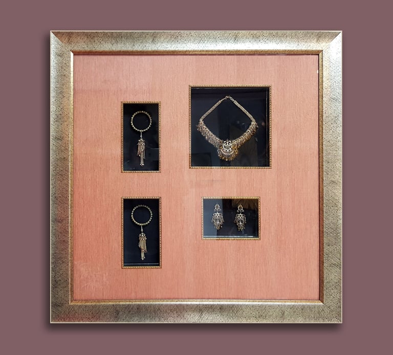 A uniquely customized shadow box frame displaying antique jewelries