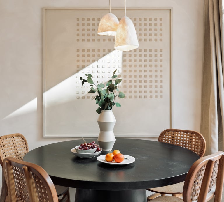Subtle dining area with custom art piece and natural wood accents in Barcelona