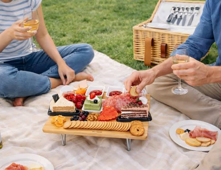 Couple enjoying picnic charcuterie board with wine outdoors