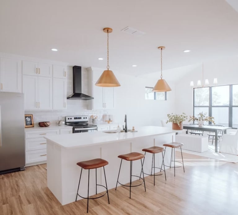 Kitchen remodel with a large island, bar seating, pendant lighting, and stainless steel appliances.