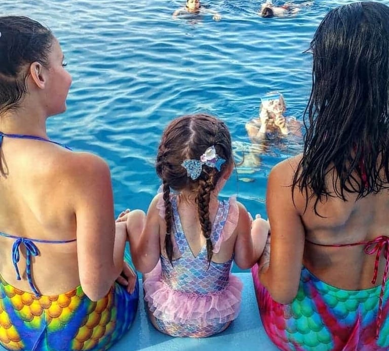 Mermaids entertaining children during a family boat tour in Protaras