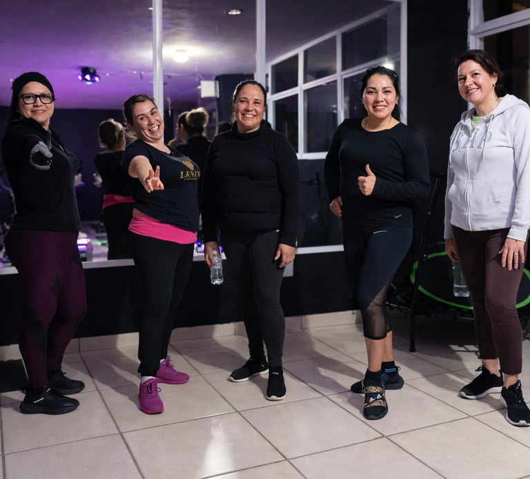 Grupo diverso de mujeres posando y sonriendo después de un entrenamiento