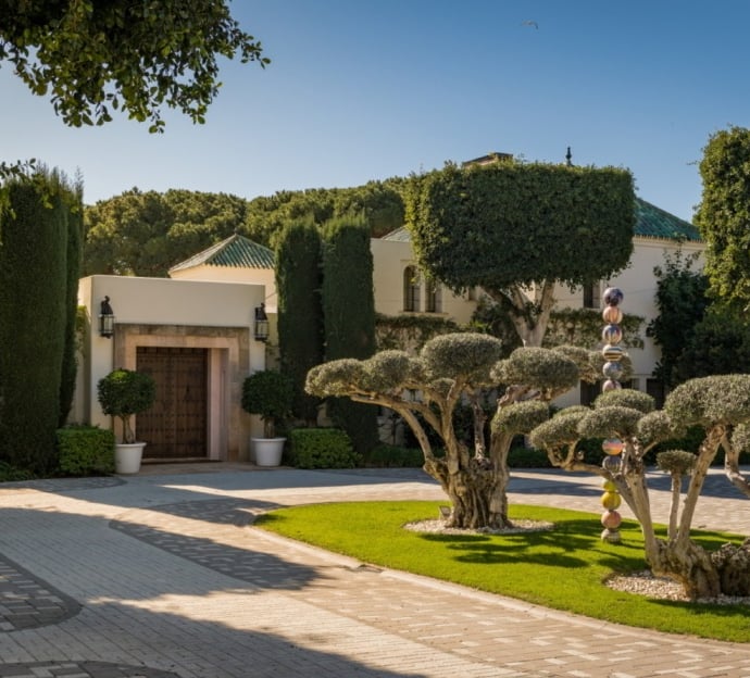 Main entrance of Villa El Rincon in Marbella, featuring a grand rotunda framed by two elegant olive trees.