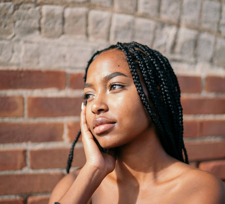 a black girl with black hair, caramel skin and a black dress