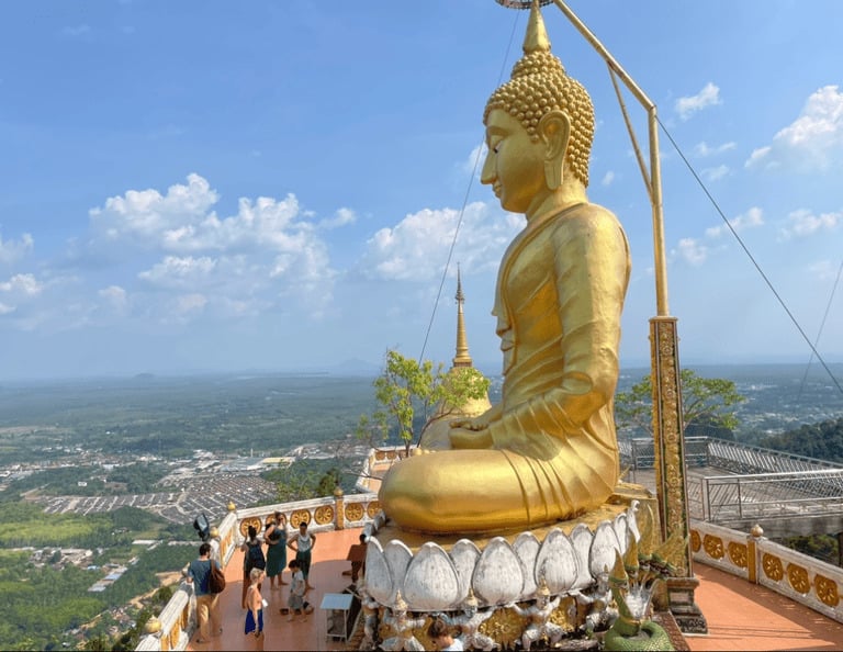 Riesige goldene Buddha-Statue am Tiger Cave Temple in Krabi, Thailand, mit Blick über das Tal.