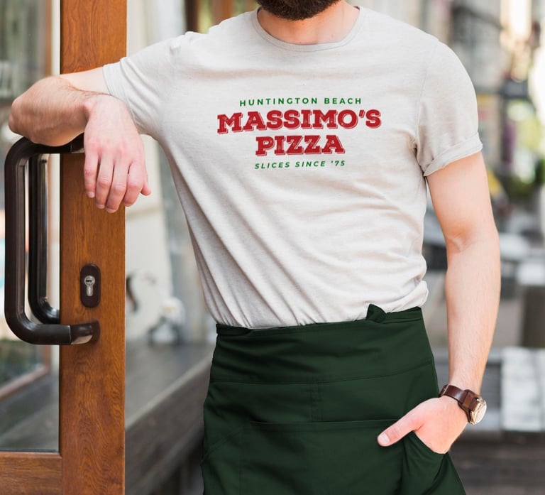 Massimo’s Pizza rebrand logo on staff t-shirt and green apron.