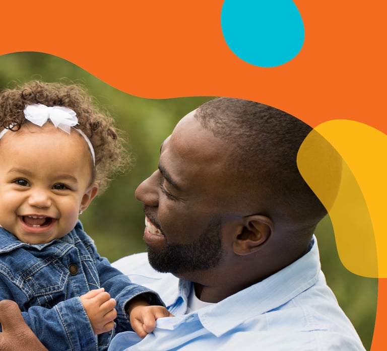 Man cheerfully holding his daughter in a frame of orange yellow and blue organic shapes.