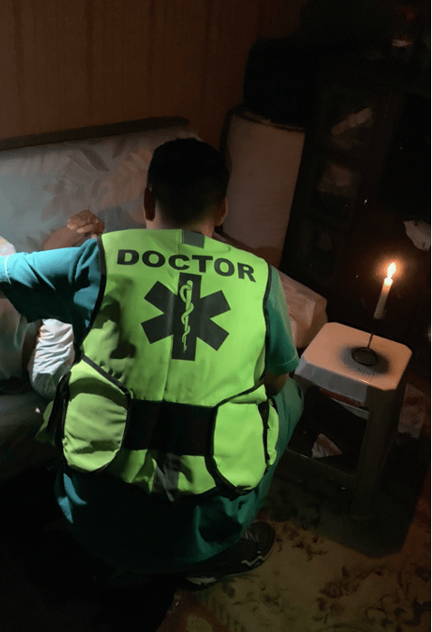 a doctor in mongolia providing care by candlelight