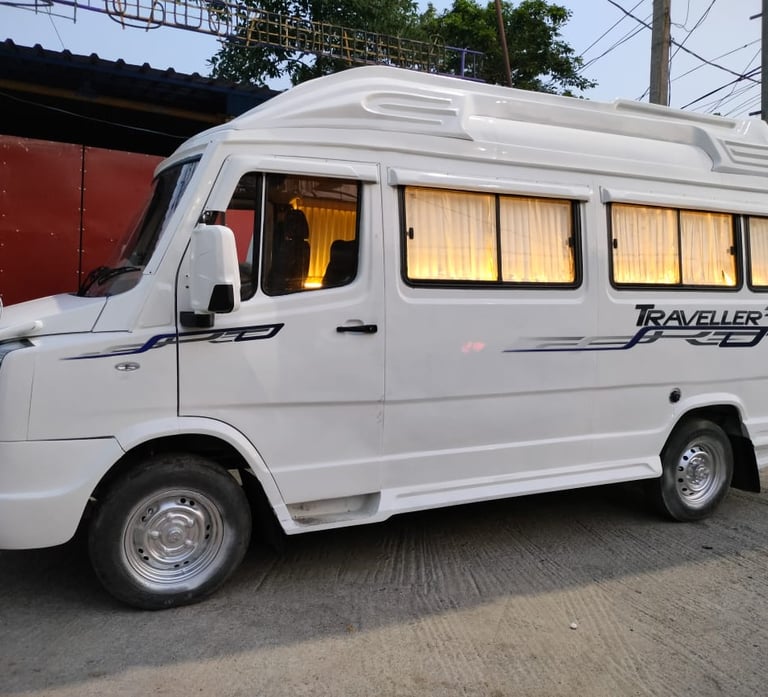 White Tempo Traveller van for rent in Chennai, parked near a red building.