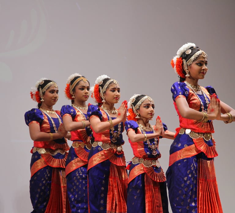 5 bharatanatyam students, standing in line, before the next step and movement.