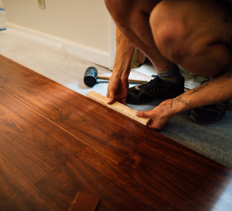 a man is using a tape measure ruler to measure a hardwood floor