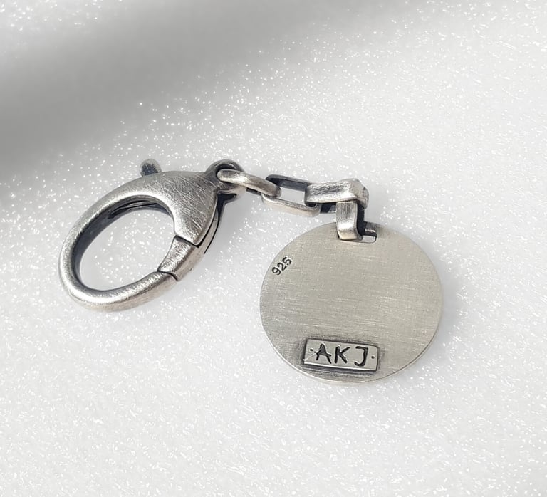 Oxidized sterling silver 925 lobster claw clasp with a round designer charm featuring an AKJ hallmark.
