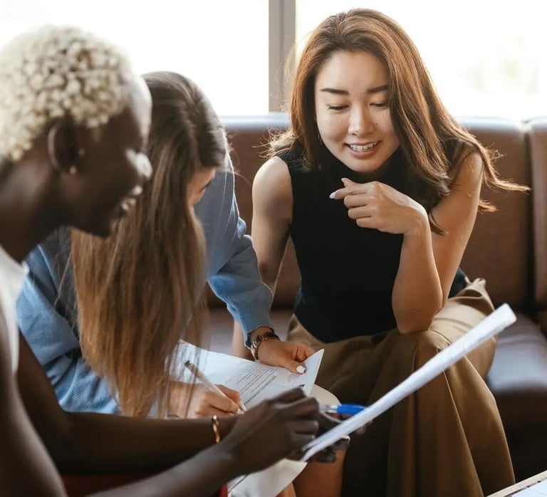 a woman sitting on a couch with a laptop and a notebook