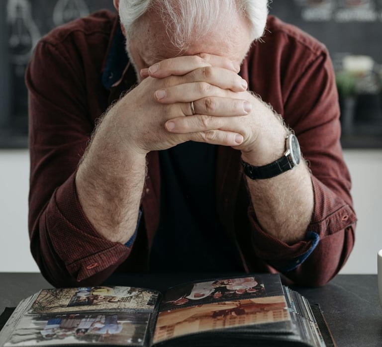 a man with elbows on table and head down