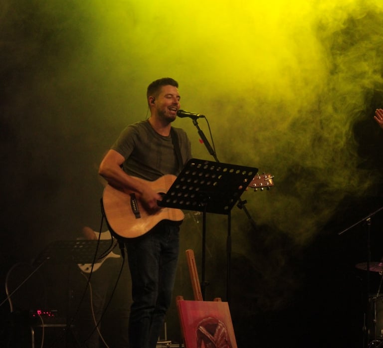 a man singing playing guitar and leading worship