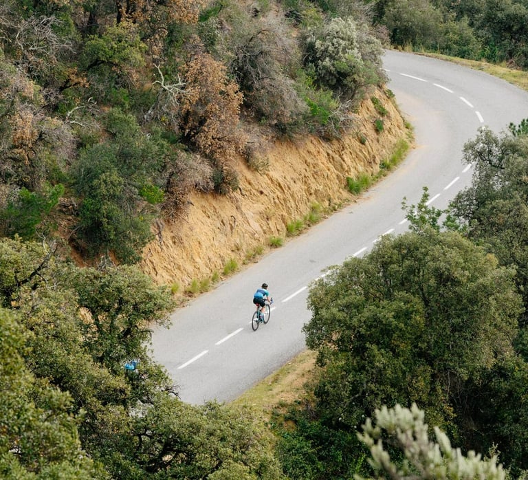 Liz Hughes, a female cyclist descending a mountain on a road bike.