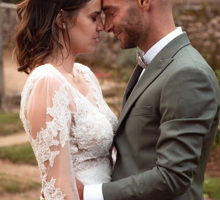 la mariée et le marié se tenant l'un contre l'autre, les yeux fermées plein d'amour