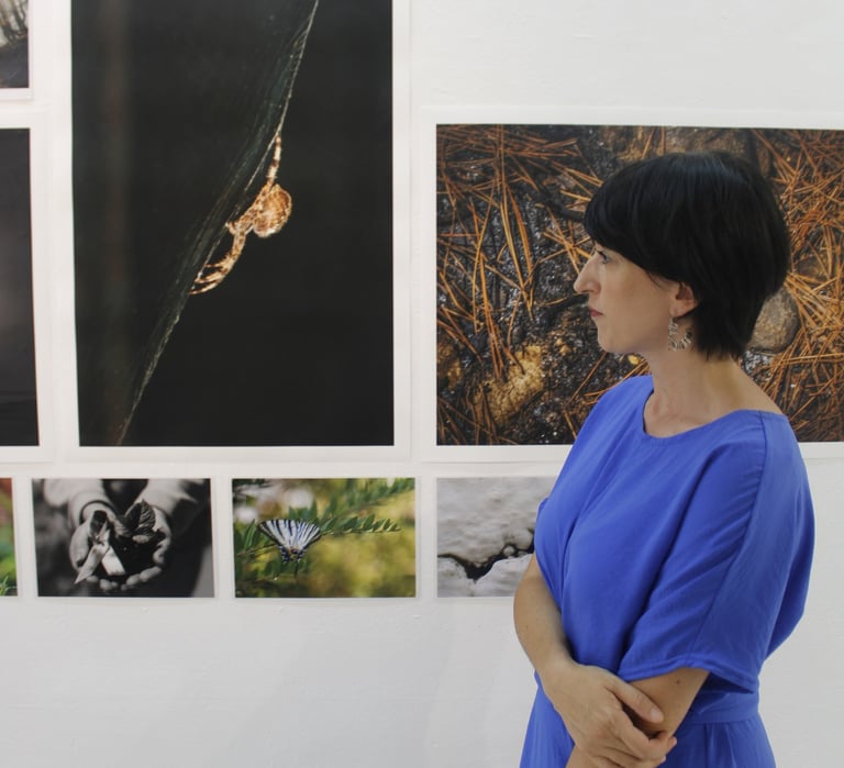 Ασημίνα Γεωργακοπούλου μπροστά από φωτογραφίες της έκθεσης του Eyes of Light