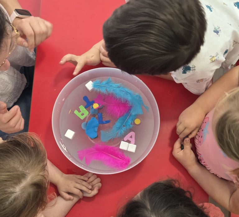 enfants qui jouent avec des objets qui flottent dans un saladier