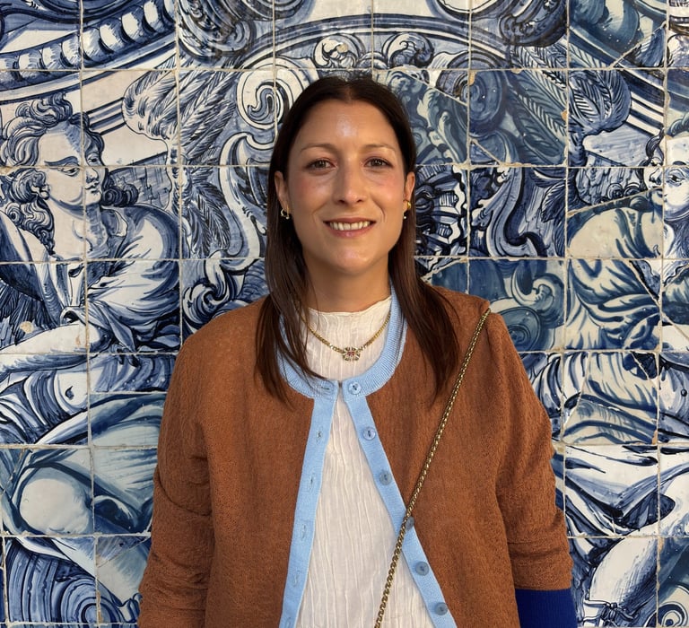 a woman standing in front of a blue tile wall