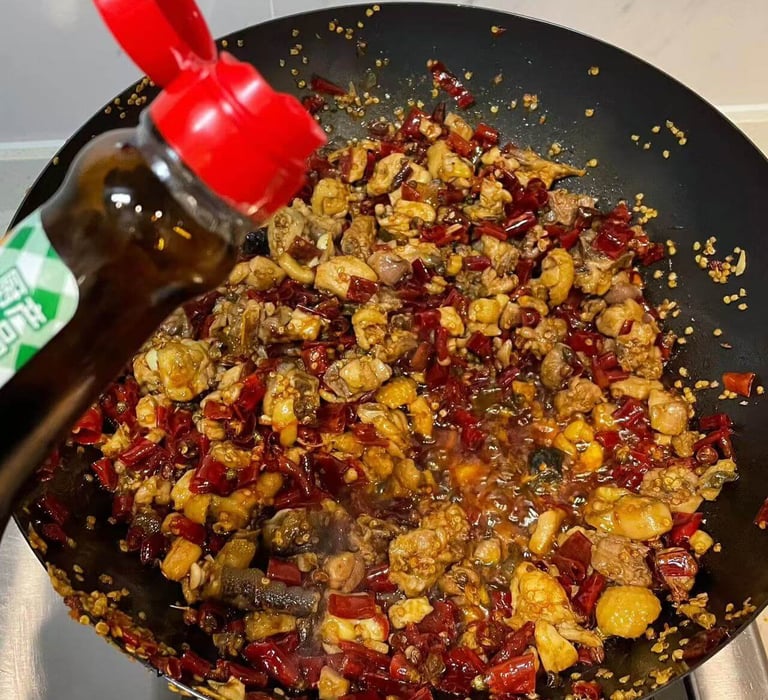 a pancaked with a bottle of soy sauce being poured into a pan