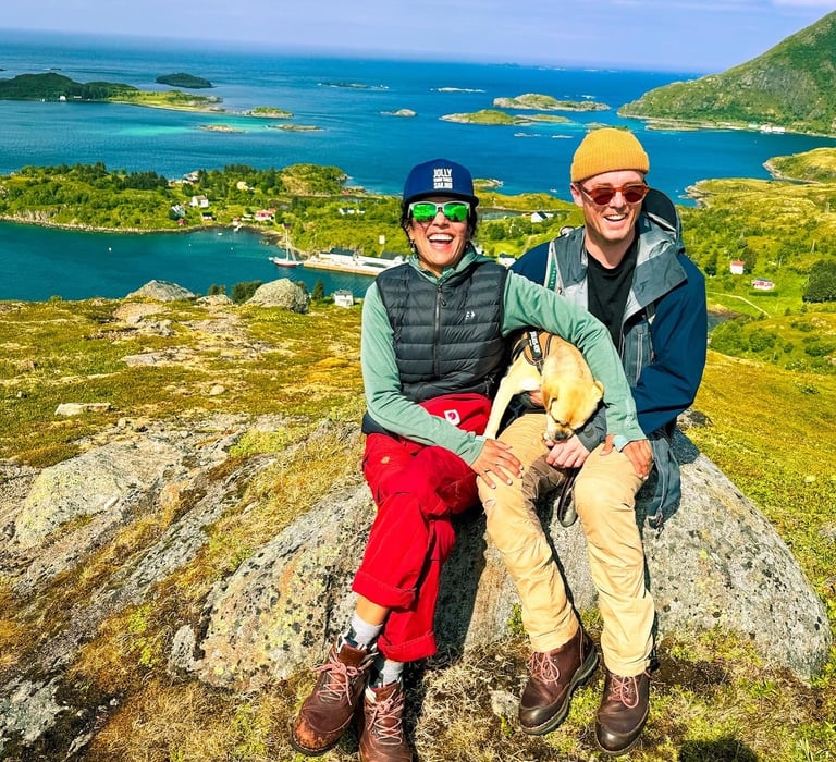 a man and woman sitting on a rock in the mountains of the Lofoten islands | Island hopping