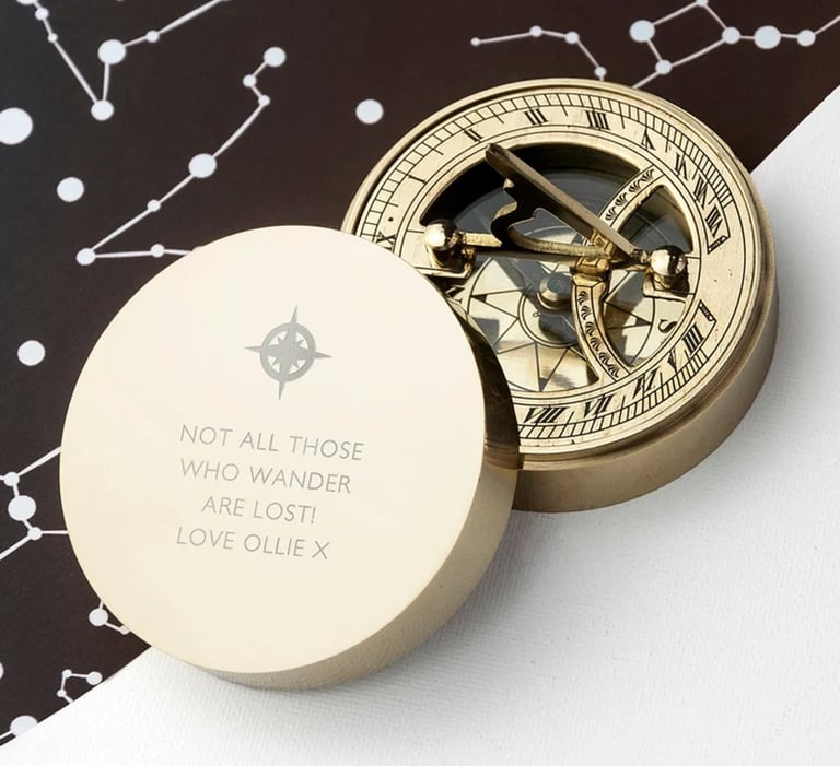 a gold compass  with a quote on it