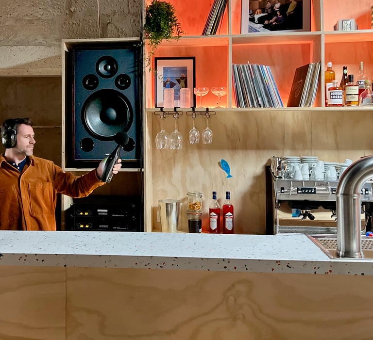 Un homme enregistre du son avec un sonomètre et un casque dans un bar