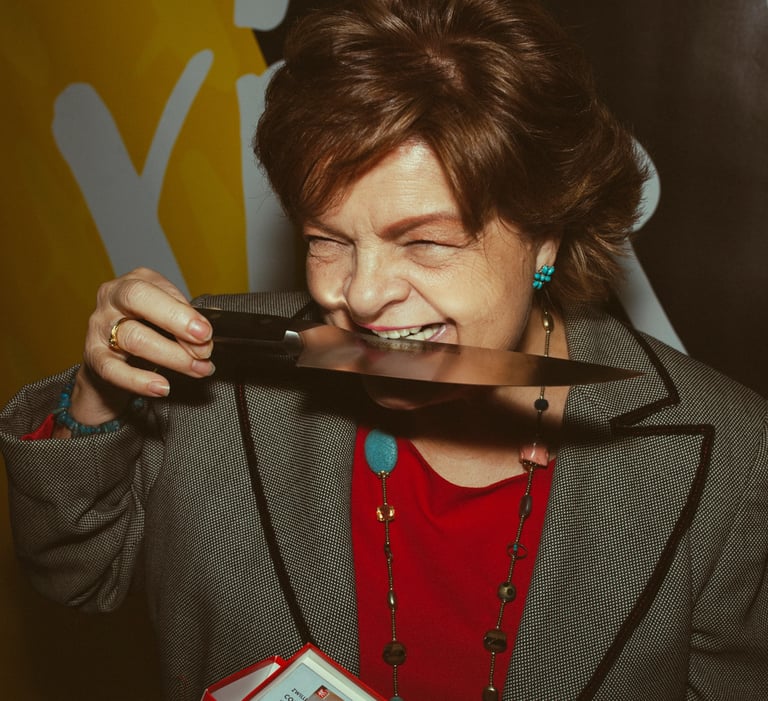 Mujer mayor divertida mordiendo un cuchillo y riendo para la marca de cuchillos Zwilling