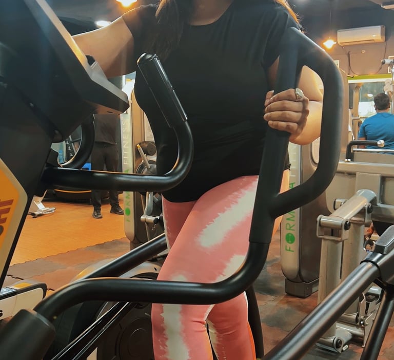 a woman in a black shirt and pink leggings on a stationary bike