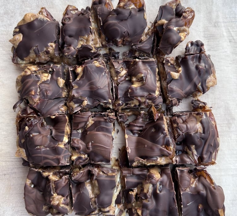 Close-up of no-bake date squares made with dates, nut butter covered with chocolate