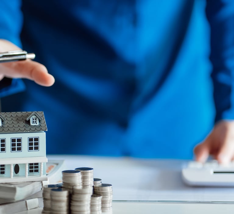 Estimation immobilière d'une maison. Le conseiller immobilier porte une chemise bleue et a un stylo.