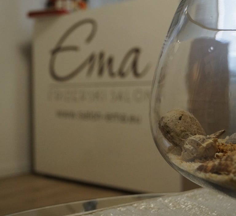 Detalj interijera Frizerskog salona Ema Zagreb – recepcija s logotipom salona i dekorativna staklena