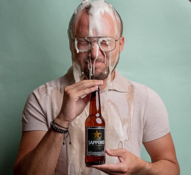 fotografía corporativa gastronómica de un hombre tirándose una cerveza sapporo por la cabeza