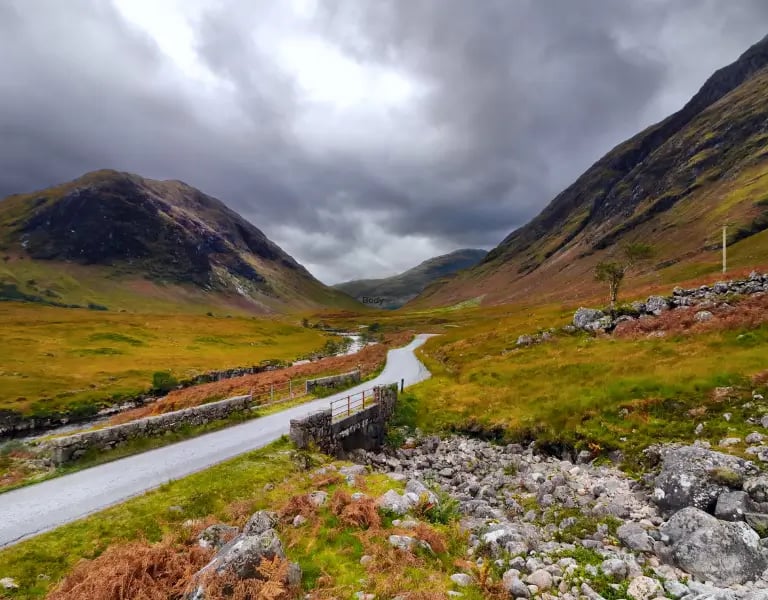 a winding road in the scottish mountains