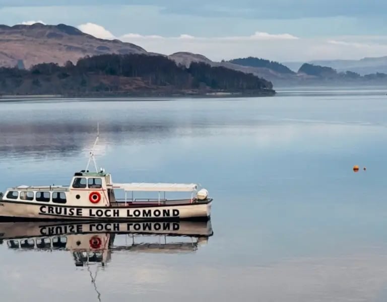 white boat on Loch Lomond with hills in the background