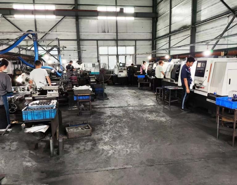 Operators working at industrial CNC machines and lathes in a manufacturing factory workshop.