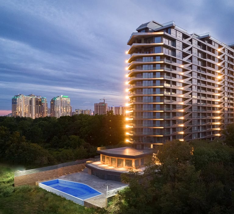 fotografia architektoniczna wielemieszzkzniowego gmachu po zachodzie słońca 