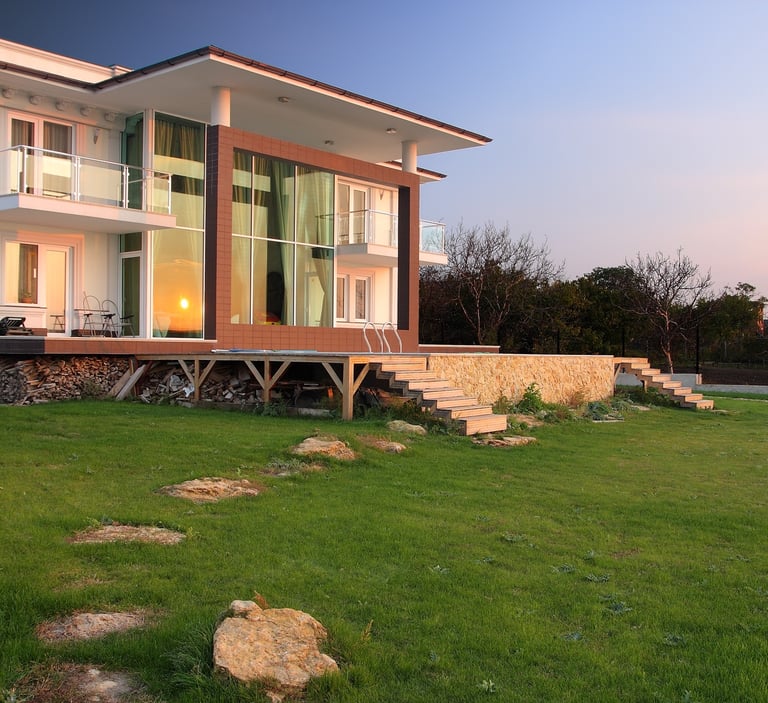 Nowoczesny dom jednorodzinny z dużymi przeszkleniami i tarasem, zachód słońca