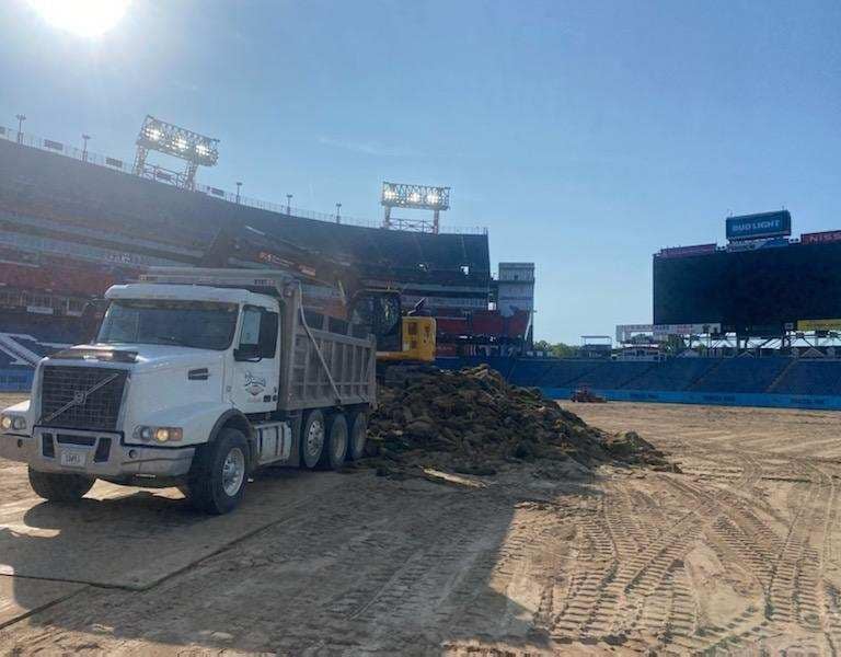 DumpTruck unloading soil to help level a playing field, material hauling